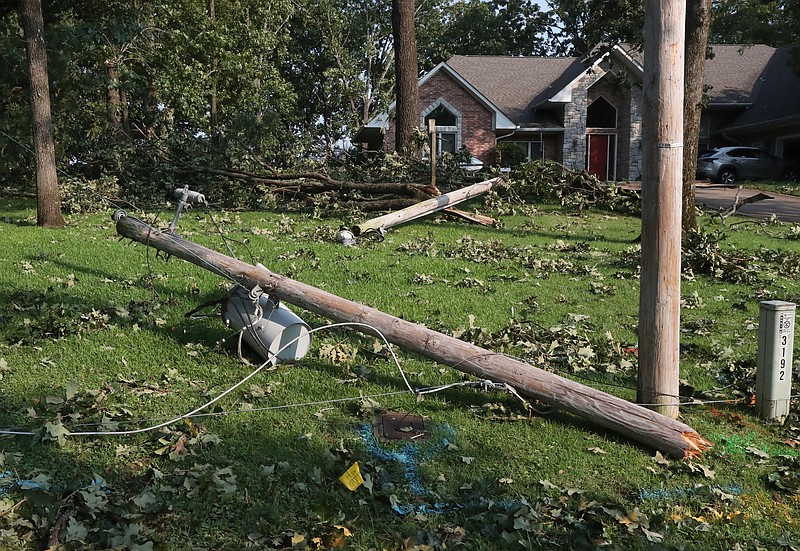 Broken utility poles litter the yard at 107 Windy Point Thursday morning, after severe weather moved through the area on Wednesday. - Photo by Richard Rasmussen of The Sentinel-Record