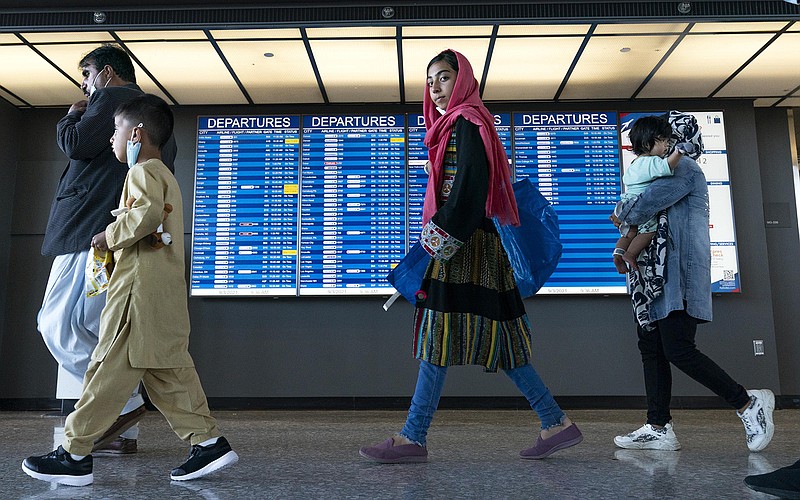 Afghan families evacuated from Kabul walk through the terminal Friday at Washington Dulles International after arriving in the United States. Tens of thousands of Afghans have begun the process of resettling, and officials said at least 50,000 refugees are expected to be admitted after the vetting process. More photos at arkansasonline.com/94afghans/.
(AP/Jose Luis Magana)