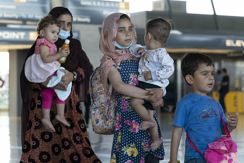 Families evacuated from Kabul, Afghanistan, walk through the terminal before boarding a bus after they arrived Thursday at Washington Dulles International Airport in Chantilly, Va.
(AP/Jose Luis Magana)