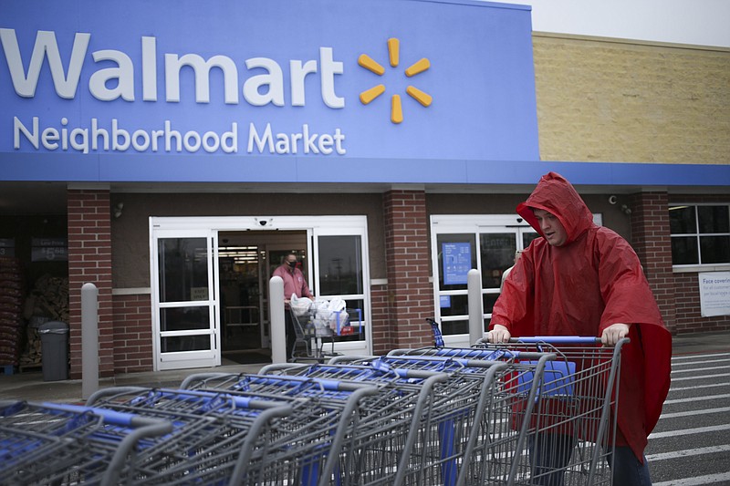 FILE -- Walmart employee Jacob Morrison pushes carts, Friday, March 12, 2021 at a Walmart Neighborhood Market in Bentonville. 
(NWA Democrat-Gazette/Charlie Kaijo)