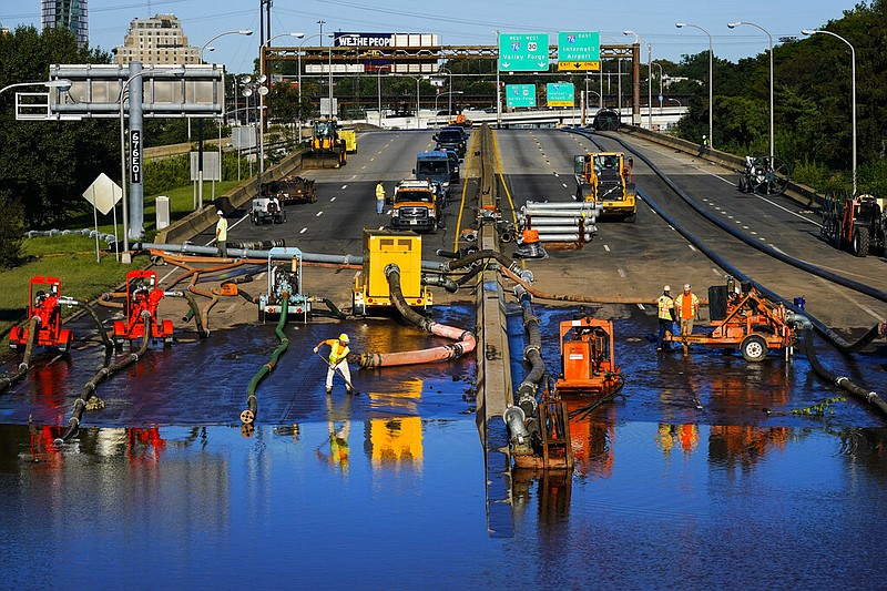 Workers pump water from a flooded section of Interstate 676 in Philadelphia Friday, Sept. 3, 2021 in the aftermath of downpours and high winds from the remnants of Hurricane Ida that hit the area. (AP/Matt Rourke)