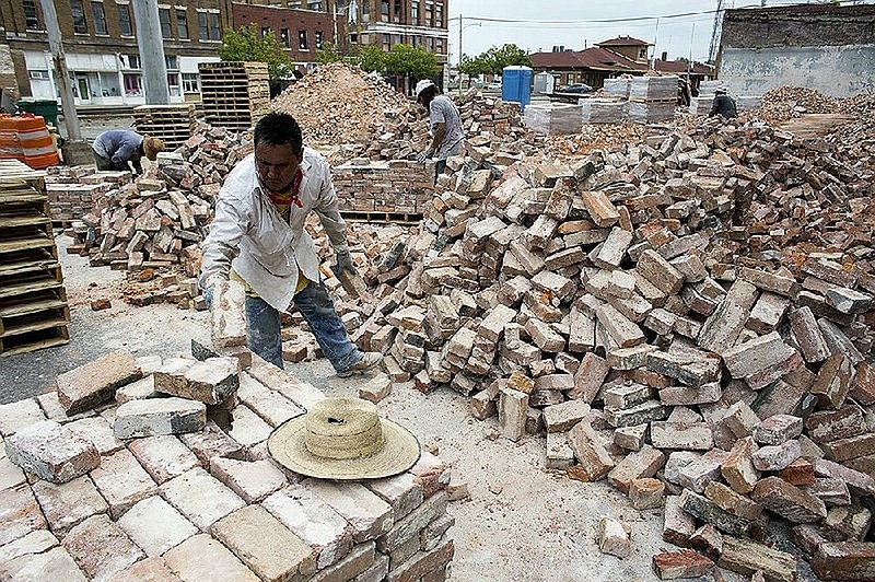 Workers organize bricks at a demolished building site on Aug. 6, 2015, off Main Street between Fourth and Fifth avenues after the former Band Museum building and a former VFW post collapsed on Feb. 21. This area is included in the Go Forward Pine Bluff strategic plan. 
(Arkansas Democrat-Gazette file)