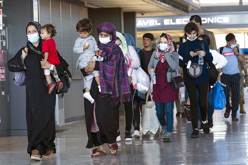 Families evacuated from Kabul, Afghanistan, walk through the terminal before boarding a bus after they arrived at Washington Dulles International Airport in Chantilly, Va., on Friday, Sept. 3, 2021. (AP/Jose Luis Magana)