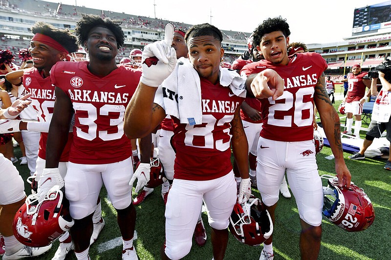 Arkansas players Kelin Burrle (33), Chris Harris (83) and Kevin Compton (26) celebrate the Razorbacks' 38-17 win over Rice in Fayetteville on Saturday, Sept. 4, 2021. (AP/Michael Woods)
