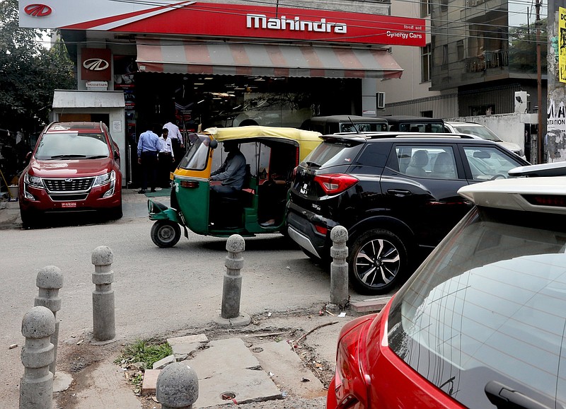 A three-wheeler passes a Mahindra and Mahindra showroom in New Delhi in this file photo. Ford, which had a partnership with Mahindra, said Thursday that it will cease auto production in India.
(AP)