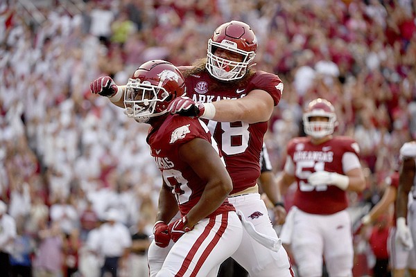 Arkansas running back Dominique Johnson (20) celebrates with Dalton Wagner (78) after scoring a touchdown against Texas during the first half of an NCAA college football game Saturday, Sept. 11, 2021, in Fayetteville. (AP Photo/Michael Woods)