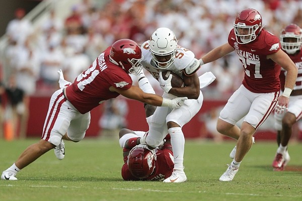 Arkansas safety Joe Foucha (ground) and linebacker Grant Morgan (31) stop Texas running back Bijan Robinson (5) on Saturday, Sept. 11, 2021 during the first quarter of a football game at Reynolds Razorback Stadium in Fayetteville. Arkansas safety Joe Foucha (ground) and linebacker Grant Morgan (31) stop Texas running back Bijan Robinson (5) on Saturday, Sept. 11, 2021 during the first quarter of a football game at Reynolds Razorback Stadium in Fayetteville.
