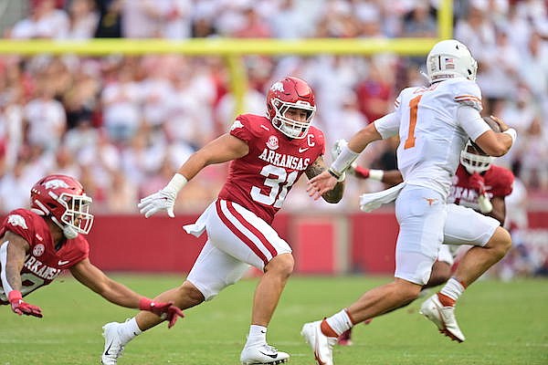 Arkansas linebacker Grant Morgan (31) chases Texas quarterback Hudson Card during a game Saturday, Sept. 11, 2021, in Fayetteville.
