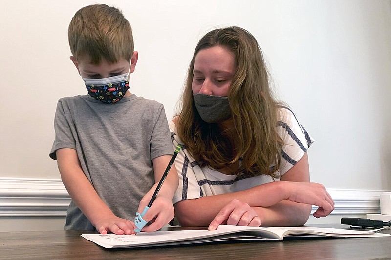 Emily Goss goes over school work at the kitchen table with her five-year-old son inside their Monroe, N.C., home on Monday, Sept. 13, 2021. (AP/Sarah Blake Morgan)