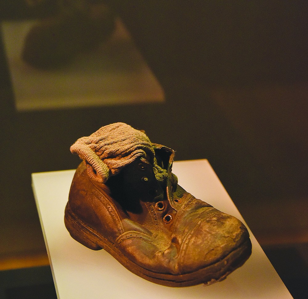 Many visitors to the “Auschwitz. Not long ago. Not far away” exhibit currently open at Union Station in Kansas City, Mo., talk about a single little shoe, with a tiny sock tucked neatly inside it, as the most poignant artifact of the World War II death camp, imagining a child expecting to put his shoes back on after a “shower.”
(Pawel Sawicki, Auschwitz Memorial)