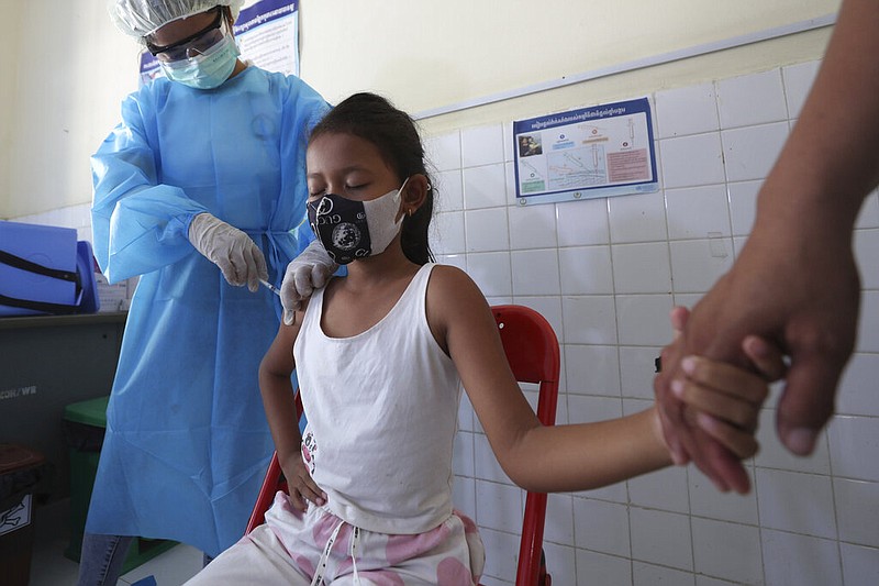 A girl holds her mother’s hand Friday while getting a shot of the Sinovac covid-19 vaccine at a health center outside Phnom Penh, Cambodia, as a nationwide campaign begins to vaccinate children ages 6-11 so they can safely return to school.
(AP/Heng Sinith)