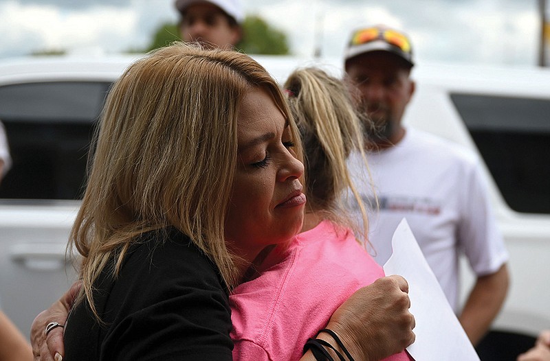 Mary Brittain (left), Hunter Brittain’s aunt, embraces friends and family members Friday outside the Pope County Courthouse in Russellville after the charges against former Lonoke County deputy Michael Davis were announced. More photos at arkansasonline.com/918hunter/.
(Arkansas Democrat-Gazette/Stephen Swofford)