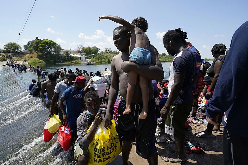 Haitian migrants cross into and out of the United States on Saturday after buying water, food and diapers in Ciudad Acuna in Mexico and then returning to an encampment at a bridge in Del Rio, Texas. More photos at arkansasonline.com/919txcamp/.
(AP/Eric Gay)