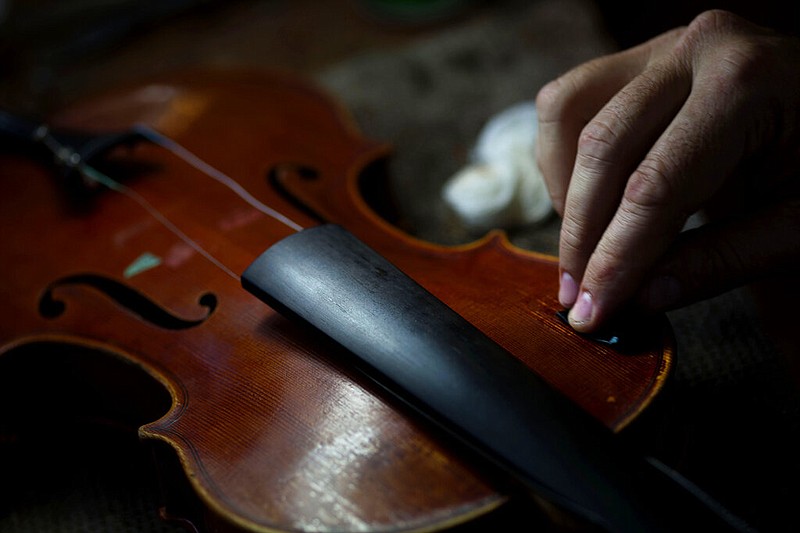 A man repairs a violin in his workshop in this Oct. 6, 2014, file photo. (AP/Ramon Espinosa)