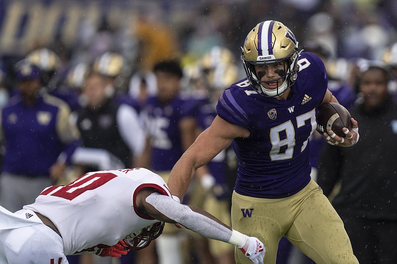 Washington tight end Cade Otton runs with the ball after a reception as Arkansas State defensive back Elery Alexander attempts to make a tackle during an NCAA football game on Saturday, Sept. 18, 2021, in Seattle. Washington won 52-3. (AP Photo/Stephen Brashear)