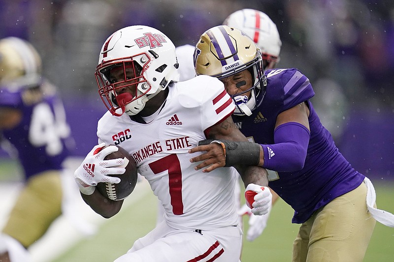 Arkansas State's Corey Rucker (7) is brought down by Washington's Cameron Williams in the second half of an NCAA college football game, Saturday, Sept. 18, 2021, in Seattle. (AP Photo/Elaine Thompson)