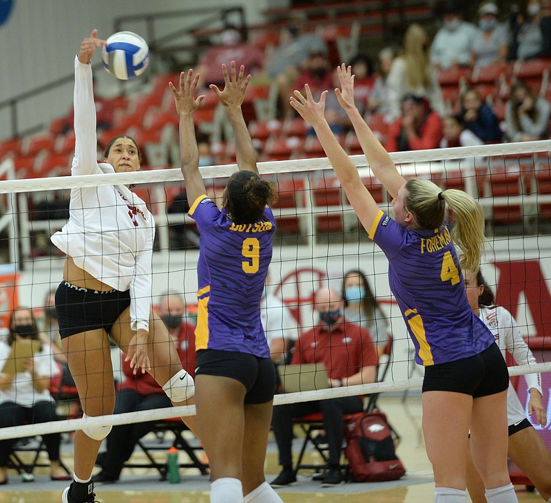 Arkansas middle blocker Ellease Crumpton (left) sends the ball over the net as LSU’s Sanaa Dotson and Whitney Foreman defend during Wednesday’s SEC match at Barnhill Arena in Fayetteville.
(NWA Democrat-Gazette/Andy Shupe)