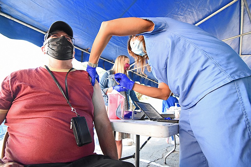 Joel Gordon of Jacksonville receives a dose of the coronavirus vaccine from Barbara McDonald, a family nurse practitioner for University of Arkansas for Medical Sciences during the vaccine clinic and job fair hosted by the City of North Little Rock on Wednesday, Sept. 22, 2021, at the Chamber of Commerce. (Arkansas Democrat-Gazette/Staci Vandagriff)