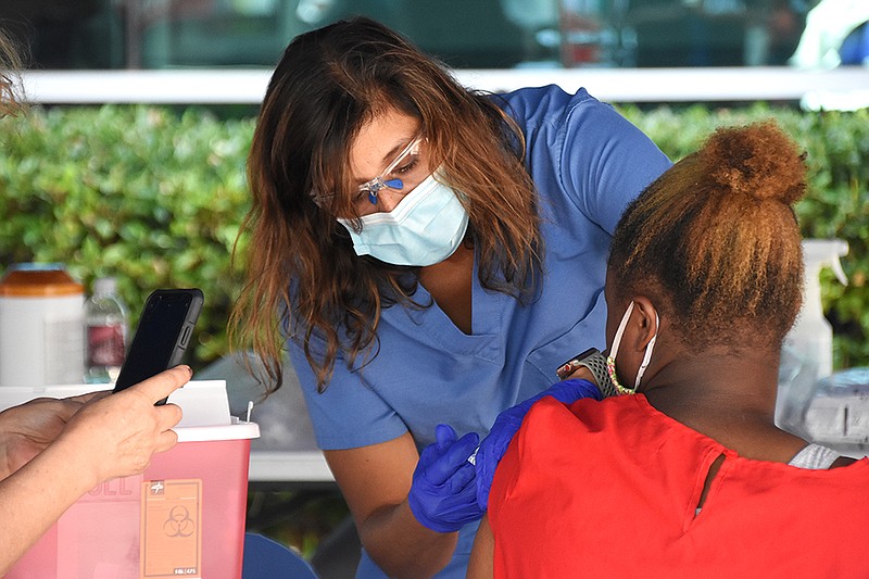 Barbara McDonald, a family nurse practitioner for University of Arkansas for Medical Sciences, administers a dose of the coronavirus vaccine during the vaccine clinic and job fair hosted by the City of North Little Rock on Wednesday, Sept. 22, 2021, at the Chamber of Commerce. (Arkansas Democrat-Gazette/Staci Vandagriff)