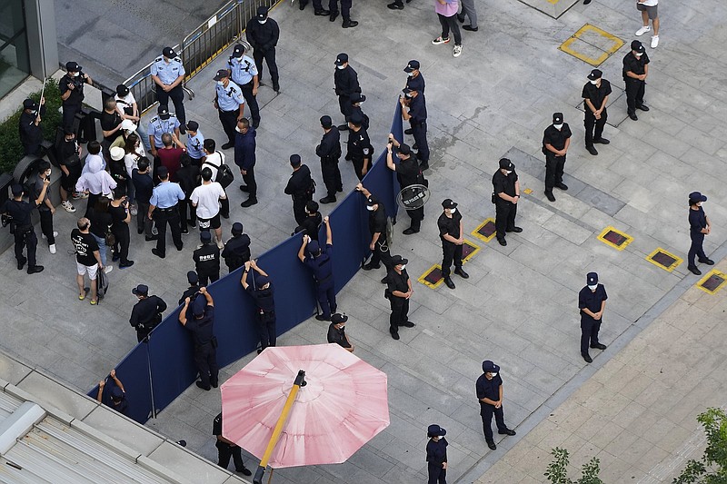 Police and security personnel surround investors Thursday as they try to enter the headquarters of the real estate developer Evergrande Group in Shenzhen, China.
(AP/Ng Han Guan)