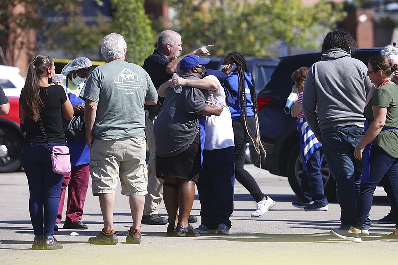 People embrace as police respond to the scene of a shooting at a Kroger grocery store in Collierville, Tenn., on Thursday, Sept. 23, 2021. (Joe Rondone/The Commercial Appeal via AP)