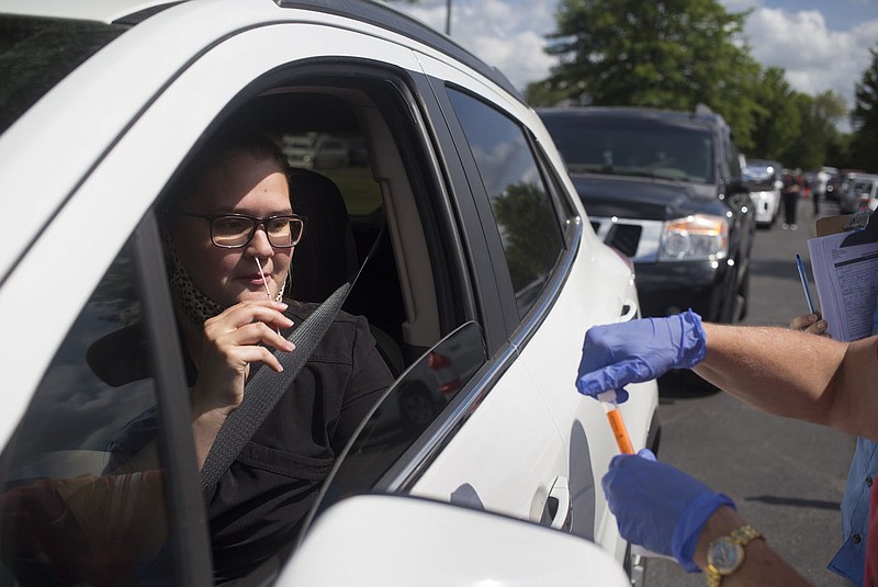 Jodie Sewell of Bentonville self-administers a nasal swab during a mass covid-19 screening at the Northwest Arkansas Community College in Bentonville in this June 26, 2020, file photo. The college provided the facility and volunteers. The University of Arkansas for Medical Sciences, or UAMS, also provided volunteers, as did Mercy Hospital. (NWA Democrat-Gazette/Charlie Kaijo)