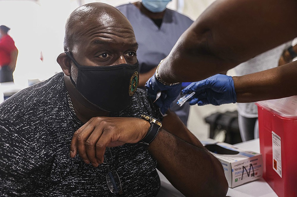 David Penelton, 53, gets a covid-19 booster shot Friday that was offered by Dallas County, Texas, on the opening day of the State Fair of Texas in Dallas. The fair was canceled in 2020 because of the pandemic, making this year’s event all that much more anticipated.
(AP/The Dallas Morning News/Lola Gomez)