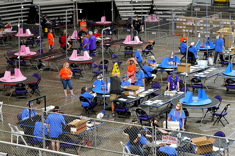 FILE - In this May 6, 2021, file photo, Maricopa County ballots cast in the 2020 general election are examined and recounted by contractors working for Florida-based company, Cyber Ninjas at Veterans Memorial Coliseum in Phoenix. (AP/Matt York, Pool, File)