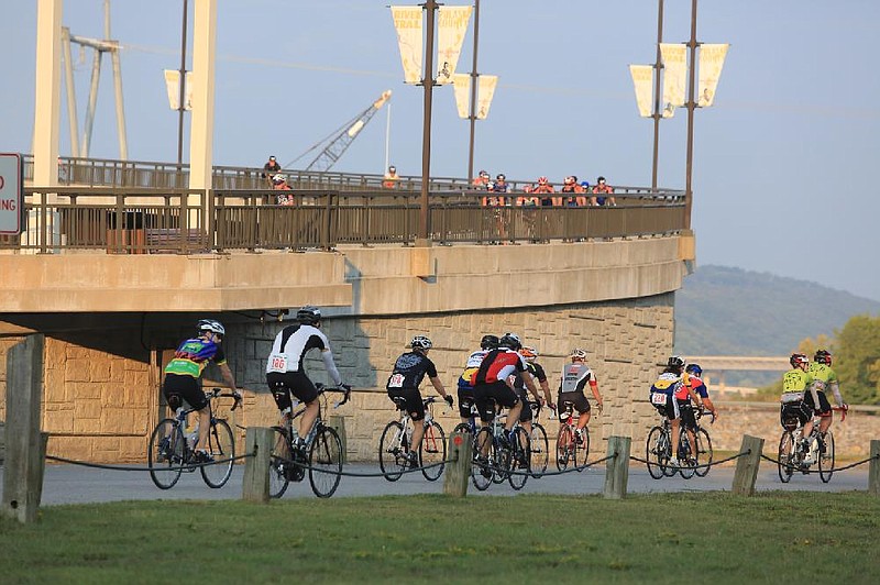 Cyclists riding in the Big Dam Bridge 100 descend from the bridge as others pass by below them in Cooks Landing in North Little Rock in this September 2013 file photo. (Arkansas Democrat-Gazette file photo)