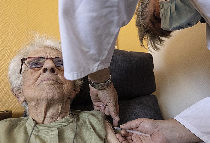 A woman gets a Pfizer booster shot Friday in a nursing home in Strasbourg in eastern France. French health officials are recommending that people with preexisting health problems and those over 65 receive third shots six months after their second doses.
(AP/Jean-Francois Badias)