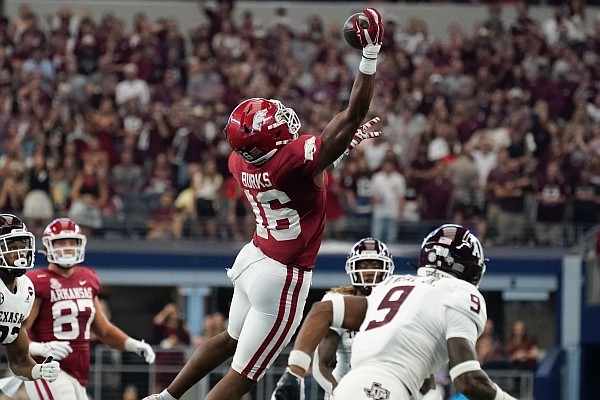 Arkansas wide receiver Treylon Burks (16) makes a one-handed catch between Texas A&M linebacker Andre White Jr. (32) and defensive back Leon O'Neal Jr. (9) in the first half of an NCAA college football game in Arlington, Texas, Saturday, Sept. 25, 2021. (AP Photo/Tony Gutierrez)