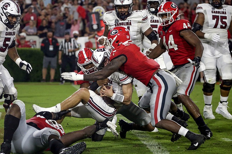 South Carolina quarterback Luke Doty (4) is tacked by linebacker Nolan Smith (4) and Georgia linebacker Quay Walker (7) in the end zone for a safety during the first half of an NCAA college football game Saturday, Sept. 18, 2021, in Athens, Ga. (AP Photo/Butch Dill)