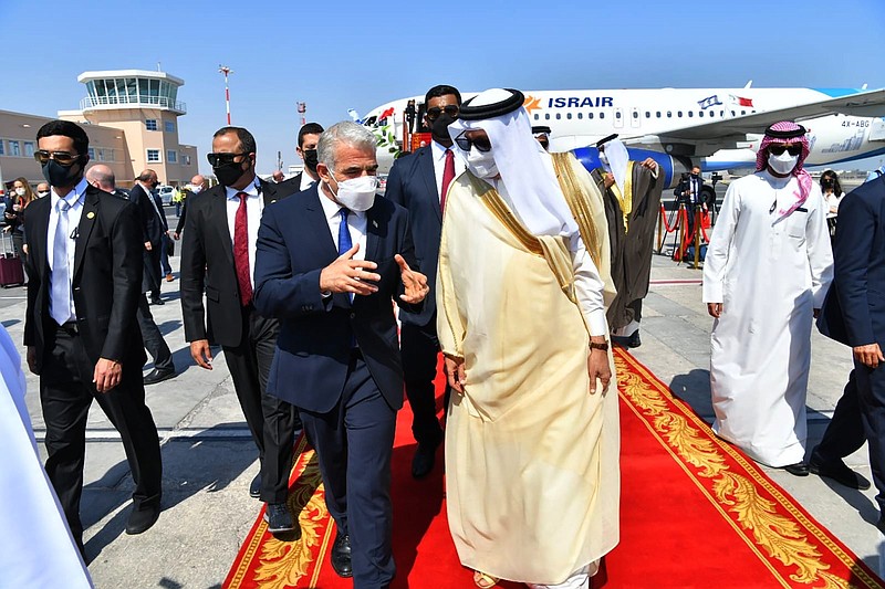 Israeli Foreign Minister Yair Lapid (left) walks with his Bahraini counterpart, Abdullatif bin Rashid Alzayani, after arriving Thursday in Manama for the first high-level talks since the establishment last year of diplomatic ties between Bahrain and Israel. More photos at arkansasonline.com/101bahrain/.
(AP/GPO/Shlomi Amshalem)