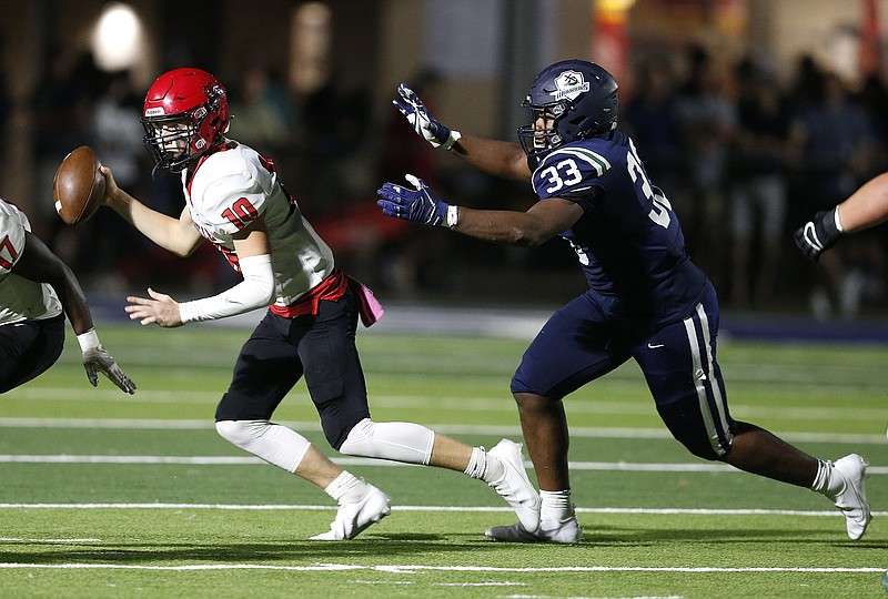 Little Rock Christian defensive lineman Titus Colquitt (right) chases Maumelle quarterback Weston Pierce during their game Friday in Little Rock. Colquitt said he felt compelled to play that night in honor of his father, Eddie Colquitt, who died two days earlier.
(Arkansas Democrat-Gazette/Thomas Metthe)