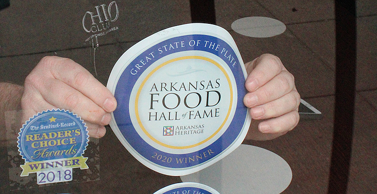 FILE — The "Burger Chef," Michael Dampier, puts a sticker on the window of the Ohio Club in Hot Springs that shows they won the People's Choice Award at the 2020 Arkansas Food Hall of Fame induction ceremony in this undated file photo. (The Sentinel-Record/Tanner Newton)