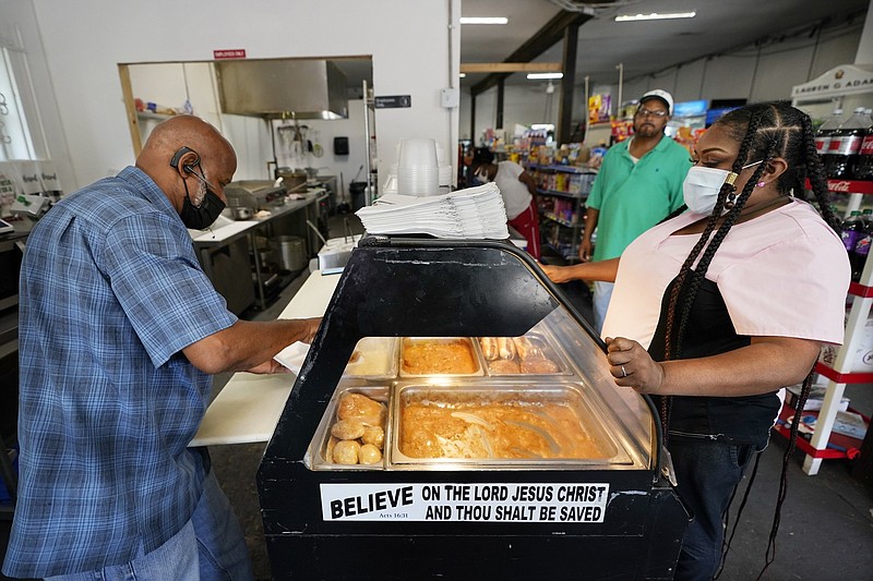 Larry Jones fills a food order for Sharon Chapman in the Variety Stop and Go store last month inStanton, Tenn. Stanton residents are both hopeful and wary about the arrival of the Ford electric pickup plant.
(AP/Mark Humphrey)