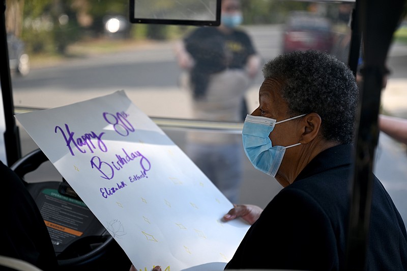 Elizabeth Eckford holds an oversized birthday card signed by students from Central High School during an 80th birthday outside the School on Monday, Oct. 4, 2021. (Arkansas Democrat-Gazette/Stephen Swofford)