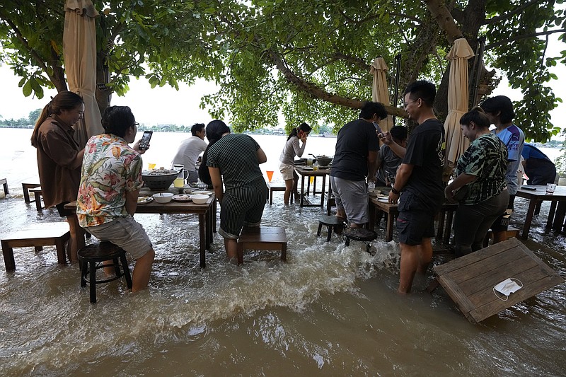 Customers of the riverside Chaopraya Antique Cafe react to a boat’s wake at their table Thursday in the Chao Phraya River in Nonthaburi, near Bangkok, Thailand. The restaurant has become an unlikely dining hotspot after fun-loving foodies began flocking to its water-logged deck.
(AP/Sakchai Lalit)