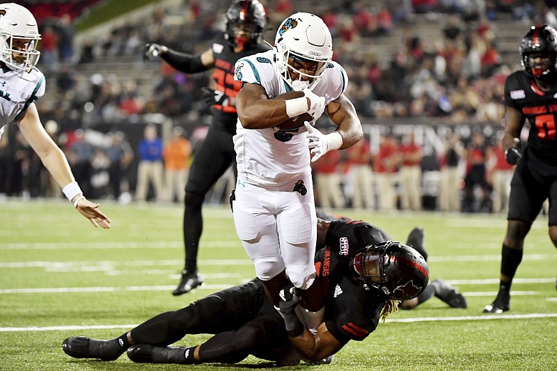 Coastal Carolina running back Shermari Jones is brought down by  Arkansas State’s David Clayton during the No. 15 Chanticleers’ victory over the Red Wolves on Thursday night in Jonesboro.
(AP/Michael Woods)