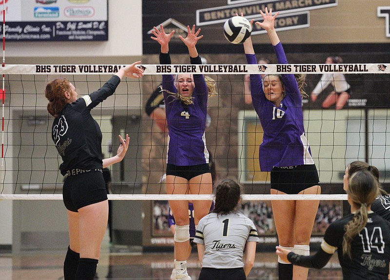 Kennedy Phelan (4) and Sophie Snodgrass (10) of Fayetteville go up for block against Maddie Lee of Bentonville during Thursday’s 6A-West Conference matchup at Tiger Arena in Bentonville. Phelan, a Florida State commit, had 10 aces and 36 assists as the Lady Bulldogs won 25-13, 25-19, 25-8. More photos at
arkansasonline.com/108fhsbhs/
(Special to the NWA Democrat-Gazette/David Beach)