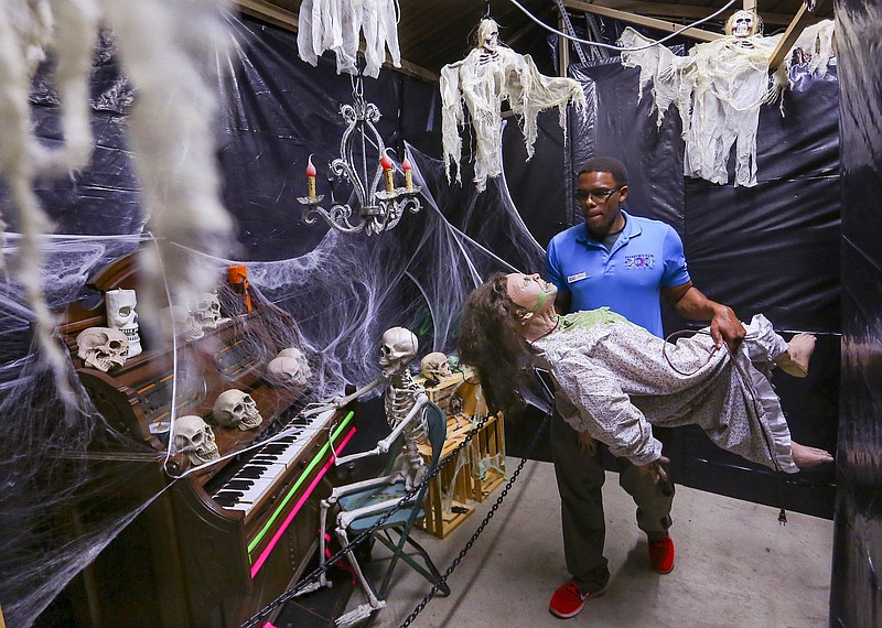 Little Rock Zoo special events staff member Deraughn Brown carries an animated halloween prop while helping set up a haunted house for Friday night's Boo at the Zoo Adult Night. The Friday event is for adults only but kids and family can attend Boo at the Zoo activities starting Saturday through Halloween night. (Arkansas Democrat-Gazette file photo)