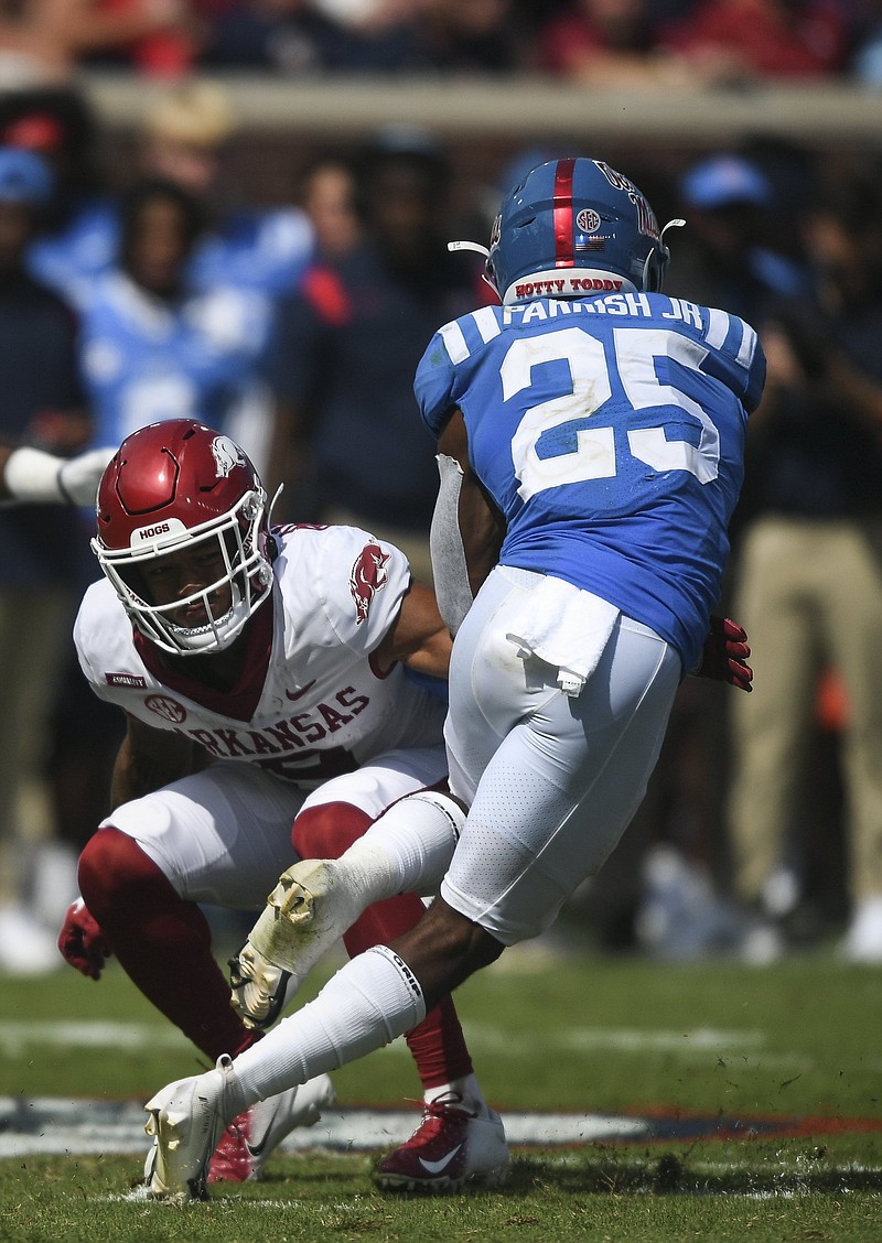Arkansas defensive back Greg Brooks Jr. (left) closes in on Ole Miss running running back Henry Parrish Jr. during Saturday’s game at Oxford, Miss. The Razorbacks allowed 324 rushing yards during the loss.
(NWA Democrat-Gazette/Charlie Kaijo)