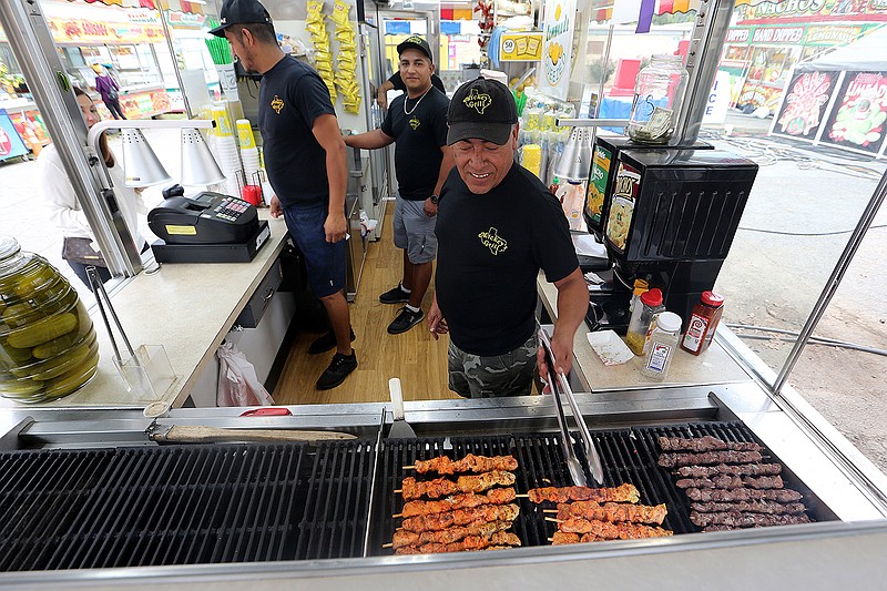 Raul Rodriguez with Mickey’s Grill cooks chicken and beef kabobs during the Arkansas State Fair preview luncheon on Thursday in Little Rock. Video at arkansasonline.com/1015fairfood.
(Arkansas Democrat-Gazette/Thomas Metthe)