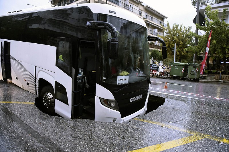 A bus is stuck in a sinkhole Friday in Thessaloniki, Greece, where rainstorms have damaged roads, closed schools and left at least two people dead.
(AP/Giannis Papanikos)
