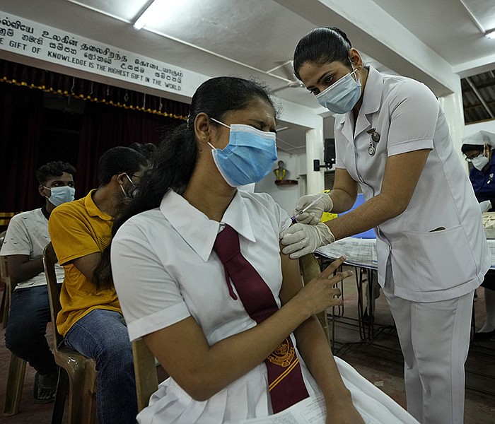 A student gets a covid-19 shot Friday in Colombo, Sri Lanka, where 18- and 19-year-olds are getting the vaccine after the government expanded the program. Sri Lanka has now vaccinated 57% of its 22 million people, officials said.
(AP/Eranga Jayawardena)