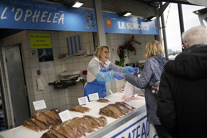 People buy fish at the market of the port of Boulogne-sur-Mer, northern France, on Friday. France wants more fishing licenses from London, but the U.K. is holding back.
(AP/Christophe Ena)