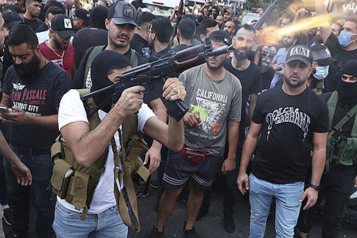 Supporters of the Shiite Amal group fire weapons Friday during the funeral procession for Hassan Jamil Nehmeh, who was killed during clashes Thursday in the southern Beirut suburb of Dahiyeh.
(AP/Bilal Hussein)