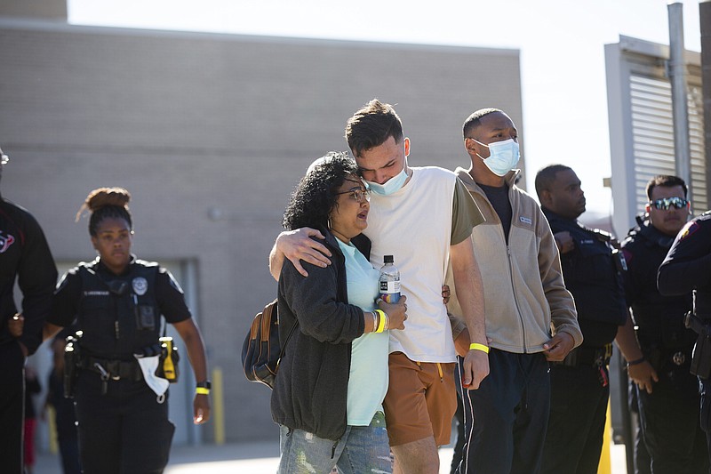 People exit the Harris County Institute of Forensic Sciences area mourning the death of a Harris County Pct. 4 deputy who was shot and killed in north Houston, Saturday, Oct. 16, 2021. Three constable deputies were shot in an ambush early Saturday morning while working an extra shift at a Houston bar. Authorities took one person into custody but were still searching for a man believed to be the shooter, Houston Police Executive Assistant Chief James Jones told reporters. (Marie D. De Jesús/Houston Chronicle via AP)