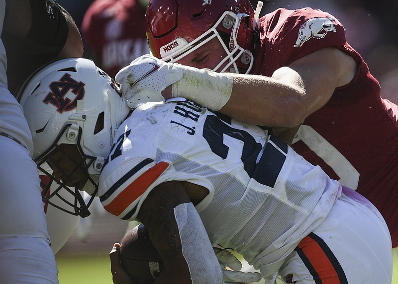 Arkansas linebacker Bumper Pool (10) tackles Auburn running back Jarquez Hunter (27), Saturday, Oct. 16, 2021, during the fourth quarter of a football game at Reynolds Razorback Stadium in Fayetteville. (NWA Democrat-Gazette/Charlie Kaijo)