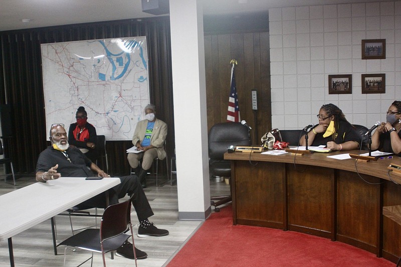 Pastor John Smith, a Crime Advisory Commissioner, and Kymara Seals, a chairman of the United Citizens of Pine Bluff, discuss ways to combat crime in Pine Bluff while committeemembers look on. 
(Pine Bluff Commercial/Eplunus Colvin)